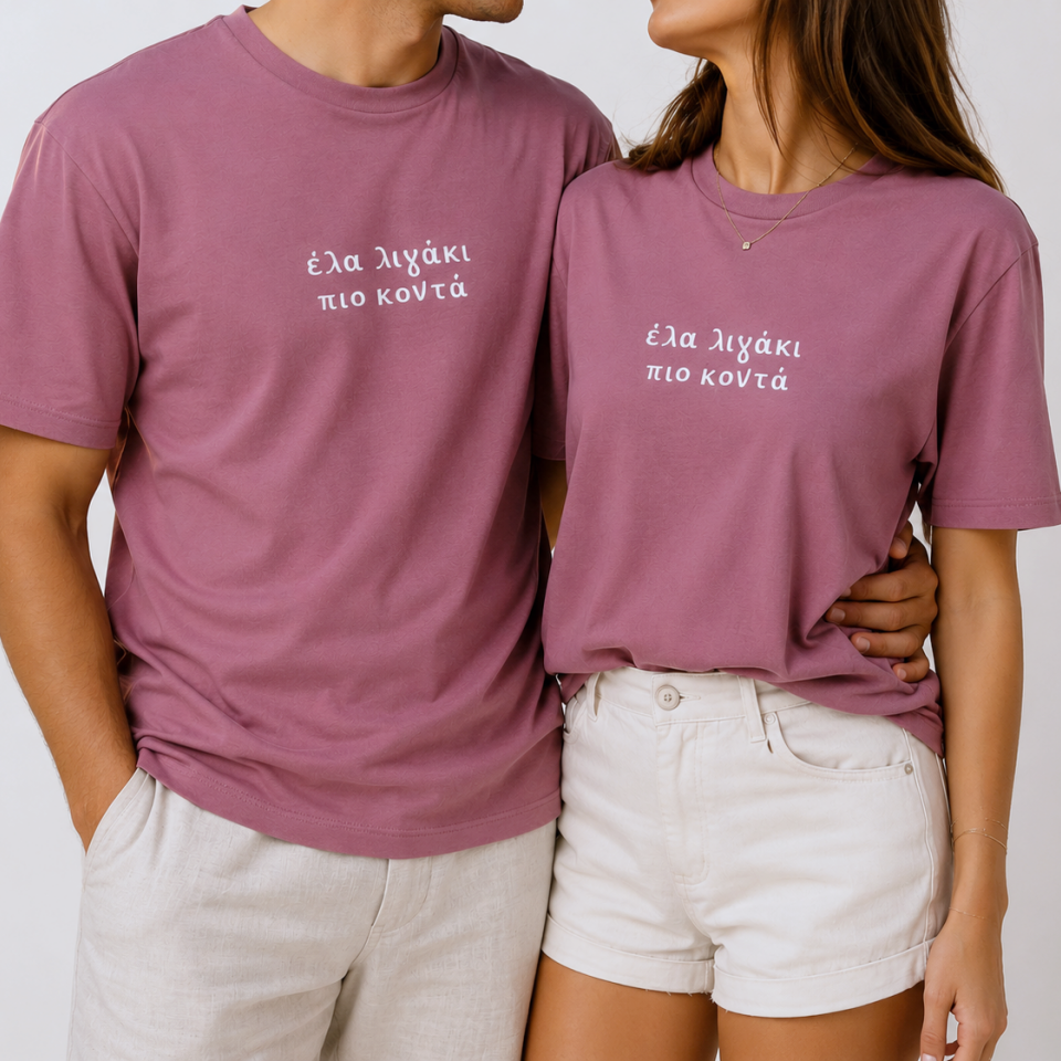 Two people wearing matching purple t-shirts with text on a plain background