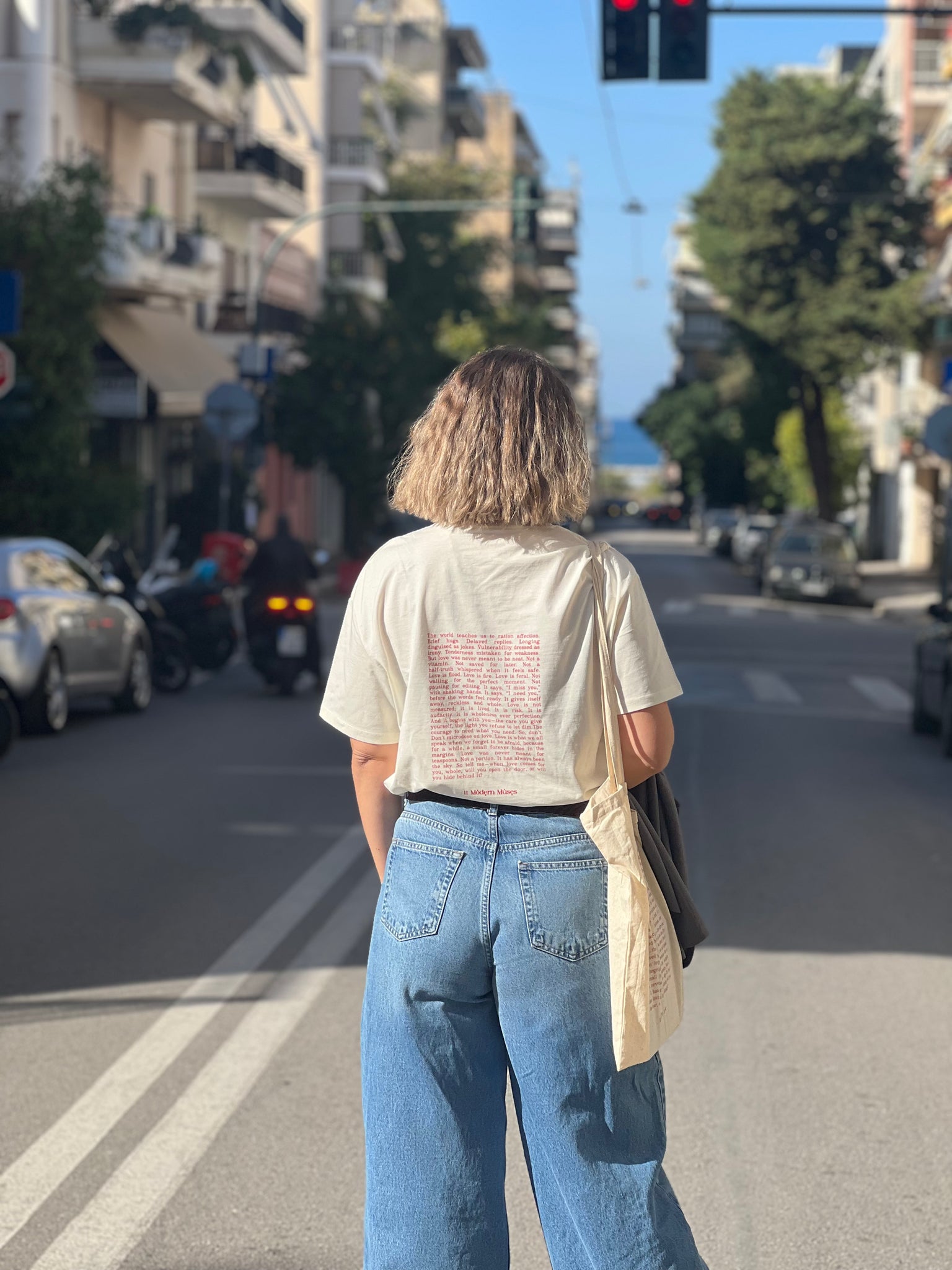A girl with aesthetics walking on a city street with buildings and traffic lights in the background