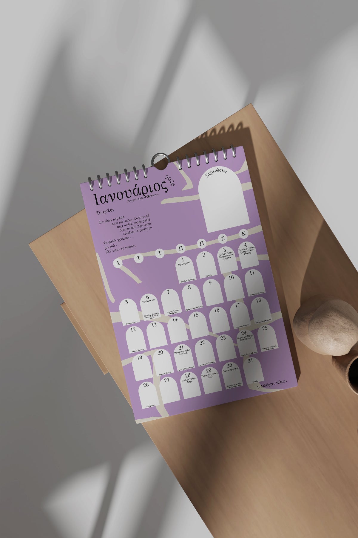 Purple spiral-bound Wall Poetry Calendar 2026 with white illustrations on a wooden surface